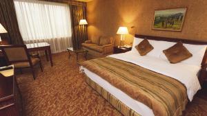 阿拉木图阿拉木图洲际酒店的酒店客房带一张大床和一把椅子