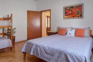 KomenSea View Karst House Apartment with Bikes的一间卧室配有一张大床,提供橙色和灰色的枕头