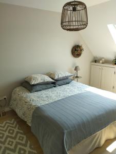 加来Le Clos des Mouettes的一间卧室配有一张带蓝色棉被的床