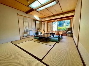 伊豆之国市Katsura no Izumi的客厅设有桌子和大窗户