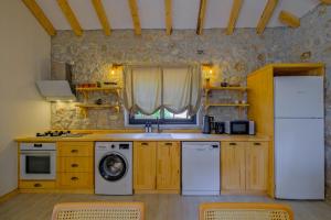 YakaPegasusstonehouse的厨房配有洗衣机、水槽和冰箱。