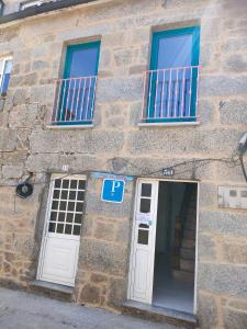 阿罗萨新镇pension mar de rosa的一座石头建筑,设有两扇窗户和一扇门