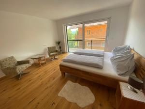 阿特湖畔努斯多夫Appartmens am Attersee Dachsteinblick的一间卧室设有一张床和一个大窗户