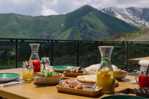 古多里Gudauri Lodge的一张桌子,上面有食物,后面有山