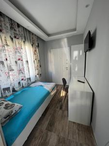 安塔利亚Yakamoz Apart Otel的一间卧室配有一张床、一张书桌和一台电视