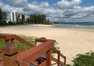 黄金海岸Cooly Coastal Escape walk to beach & shops的海滩景,设有木凳