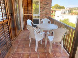 卡莱利亚德帕拉弗鲁赫尔Apartamento con espectaculares vistas al Mediterráneo的阳台的天井配有桌椅