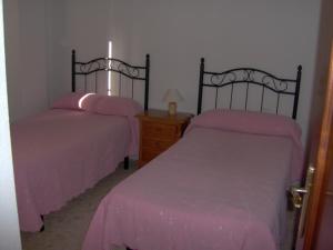 林孔-德拉维多利亚La Kentia的客房内的两张床,上面有粉红色的床单
