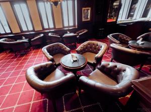 亚历山大亚历山大施泰根贝格尔塞西尔酒店的一间在房间内配有皮椅和桌子的餐厅