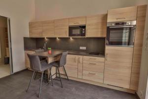 Domaine Grand Piquecaillou - L'appartement Loupiac的厨房配有木制橱柜和桌椅