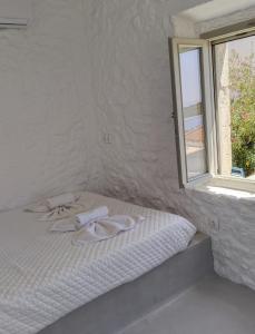 NikiáOniropagida Nisyros apartments #2 Nikia view的窗户旁的白色床和毛巾