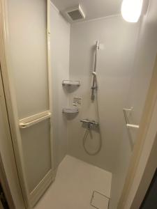 东京ステイワーク錦糸町的带淋浴和盥洗盆的白色浴室