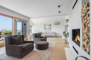 海宁格松Exclusive Family Villa in Haugesund - Lovely Ocean View, 5 Bedroom, Free parking的客厅配有两把椅子和壁炉