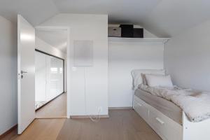 海宁格松Exclusive Family Villa in Haugesund - Lovely Ocean View, 5 Bedroom, Free parking的白色卧室配有床和镜子