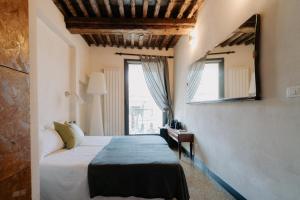 热那亚Le stanze del Piccadilly的一间卧室设有一张床和一个窗口
