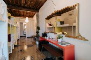 热那亚Le stanze del Piccadilly的一间设有红色书桌和镜子的客房