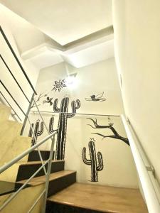 大坎皮纳Hotel Casa Blanca的仙人掌壁画,墙上有楼梯