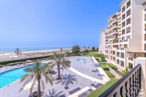 拉斯阿尔卡麦Studio in Al Hamra Village with Sea View的从度假村的阳台可欣赏到游泳池和海滩的景色