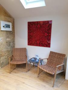 奇平卡姆登Merriman Cottage的画室里配有两把椅子和一张桌子