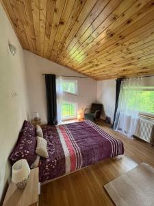 卡尔洛瓦茨Rooms Ljubenko的一间卧室设有一张带木制天花板的大床