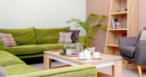 贝尔格莱德加尔尼薄荷酒店的客厅配有绿色沙发和茶几