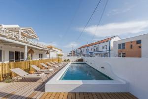 孔波尔塔Villa da Comporta - Apartamento T3的木制甲板上带躺椅的游泳池