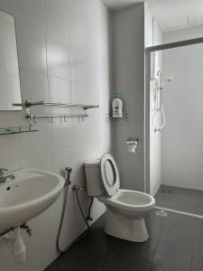 太平Mr.J Homestay的白色的浴室设有卫生间和水槽。