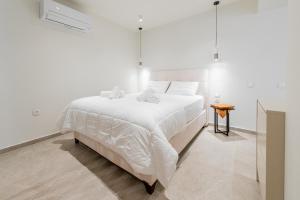 爱琴娜岛Gemela AllstarBoutique in Aegina A的白色卧室配有一张大床和一张桌子