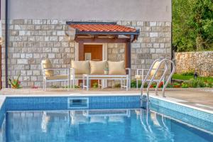 布德瓦Seaview Villa Lavanda with pool的一座房子旁带两把椅子的游泳池