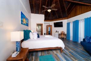 尼格瑞尔Blue Skies Beach Resort的一间卧室配有一张床和吊扇