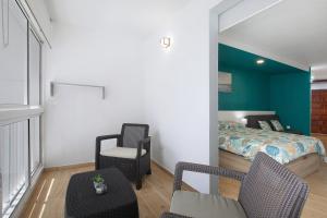 塔科龙特Mar y Sol 423的一间卧室配有一张床、一把椅子和镜子