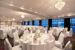 韦克斯福德斐里卡里格酒店的一个带白色桌椅的大型宴会厅