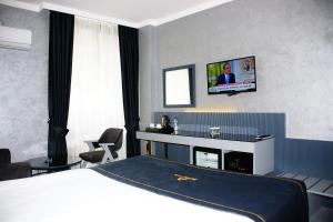 安卡拉alfin otel的酒店客房设有一张床和墙上的电视