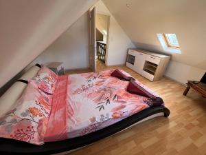 勒唐蓬La maison des camélias的一间卧室配有一张带粉色毯子的床