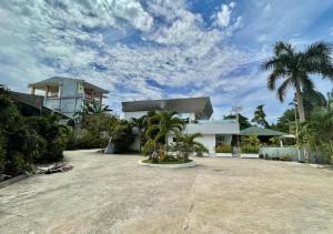 公主港Cheryl's Place Vacation Home Palawan的一座棕榈树掩映的白色房子