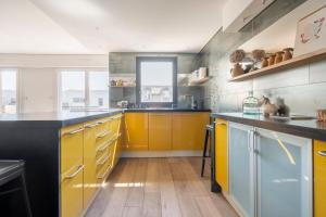 勒布尔热City Escape的一间设有黄色橱柜和木地板的大厨房