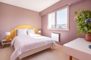勒布尔热City Escape的卧室配有白色的床和盆栽植物