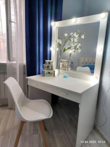 阿拉木图Стильный уют в центре的一张带镜子的白色书桌和一张白色椅子