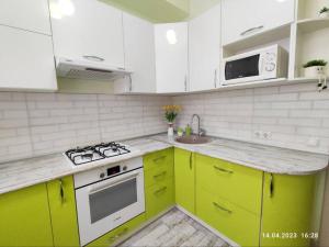 阿拉木图Стильный уют в центре的厨房配有绿色和白色的橱柜和水槽