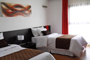 玛利亚镇阿梅里安玛丽亚公园酒店的一间卧室设有两张床,墙上挂着一幅画