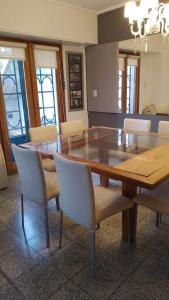 坦迪尔Casa en Tandil的一间带木桌和椅子的用餐室
