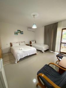 旧瓦马Vila Azaleea的酒店客房带两张床和一张桌子以及椅子。