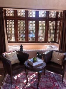 马拉喀什Villa Jolyamelkis - golf Marrakech的客厅配有两张真皮座椅和一张桌子