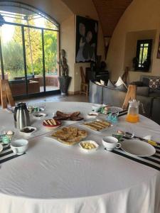 马拉喀什Villa Jolyamelkis - golf Marrakech的一张桌子,上面有白色的桌布,上面有食物