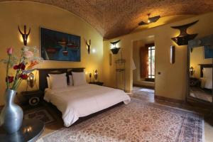 马拉喀什Villa Jolyamelkis - golf Marrakech的卧室配有白色的床和花瓶