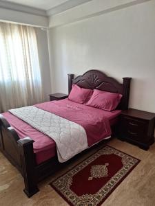 拉巴特apartment 2 bedrooms in hassan的一间卧室配有带粉色床单和粉红色枕头的床。