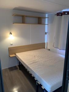 吕奥姆Mobilhome dans résidence的小房间,设有一张床和一盏灯