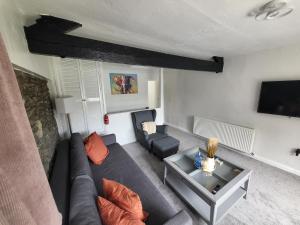 卡特梅尔Courtyard Cottage的带沙发和电视的客厅