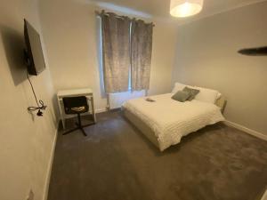 格拉斯哥Glasgow excellent lodging home的一间小卧室,配有一张床和电视