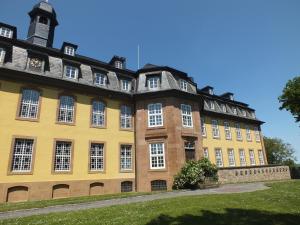 LiebenburgFerienhaus Werner的一座大型黄色建筑,在草地上设有窗户